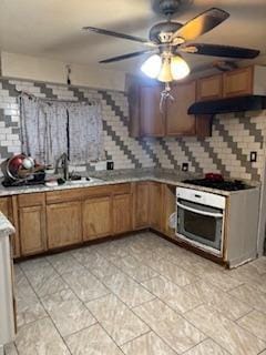 kitchen with sink, decorative backsplash, oven, and black gas cooktop