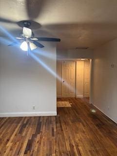 unfurnished room featuring dark wood-type flooring and ceiling fan