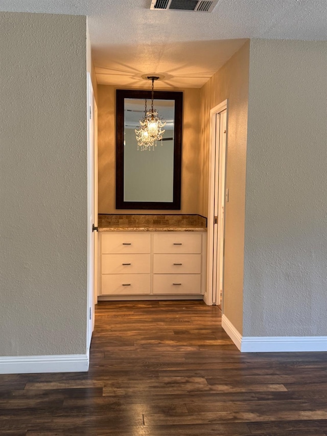 1590 W Escalon, Fresno, CA 93711 - hall with a textured wall, a chandelier, dark wood-style floors, and a textured ceiling