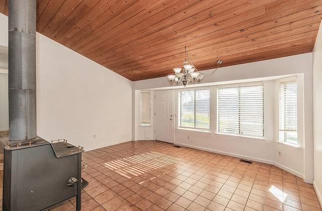 unfurnished living room featuring lofted ceiling, light tile patterned floors, wood ceiling, a chandelier, and a wood stove