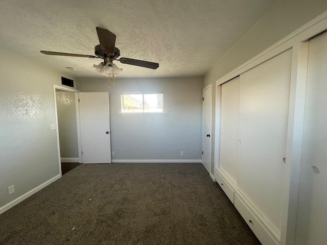 unfurnished bedroom with dark carpet, a textured ceiling, and ceiling fan