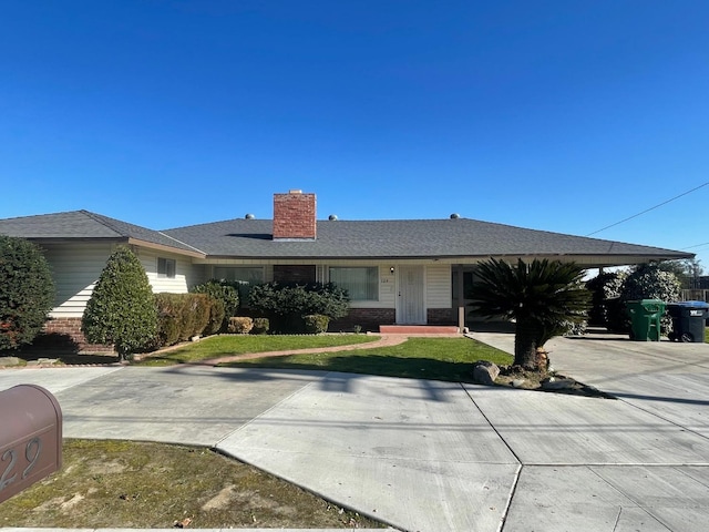 129 N Armstrong Ave, Fowler, CA 93625 - ranch-style home with brick siding, a chimney, and a front lawn