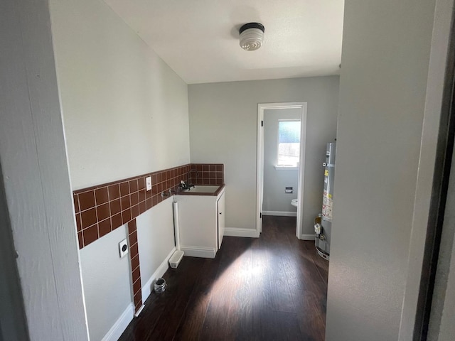 129 N Armstrong Ave, Fowler, CA 93625 - laundry area featuring dark wood finished floors, a sink, secured water heater, tile walls, and baseboards