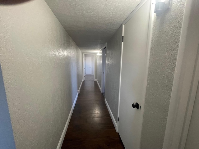 129 N Armstrong Ave, Fowler, CA 93625 - hall with a textured ceiling, a textured wall, baseboards, and dark wood-type flooring