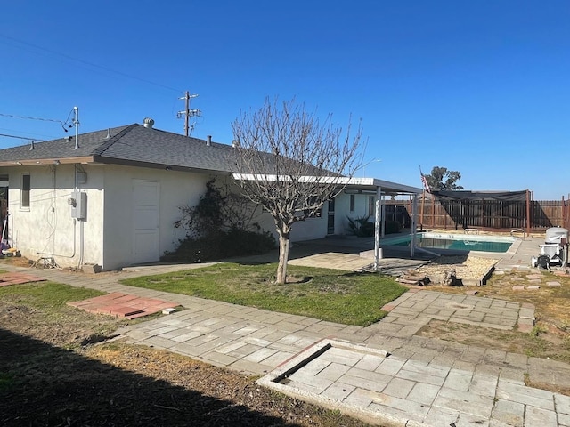 129 N Armstrong Ave, Fowler, CA 93625 - rear view of house featuring stucco siding, a patio, roof with shingles, and a fenced backyard