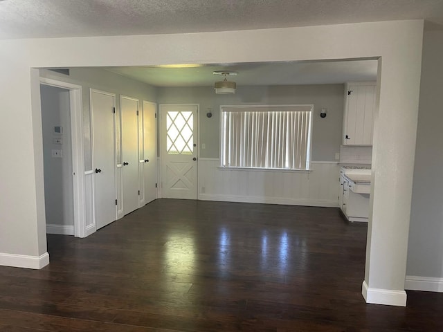 unfurnished room with dark hardwood / wood-style flooring and a textured ceiling