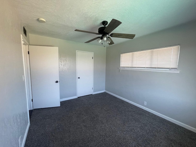 129 N Armstrong Ave, Fowler, CA 93625 - unfurnished bedroom with a textured ceiling, dark colored carpet, baseboards, and a ceiling fan
