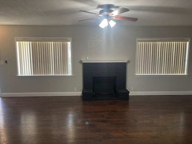 unfurnished living room featuring dark hardwood / wood-style flooring, a fireplace, and ceiling fan