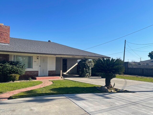 129 N Armstrong Ave, Fowler, CA 93625 - view of front of property with brick siding, a porch, a shingled roof, and a chimney