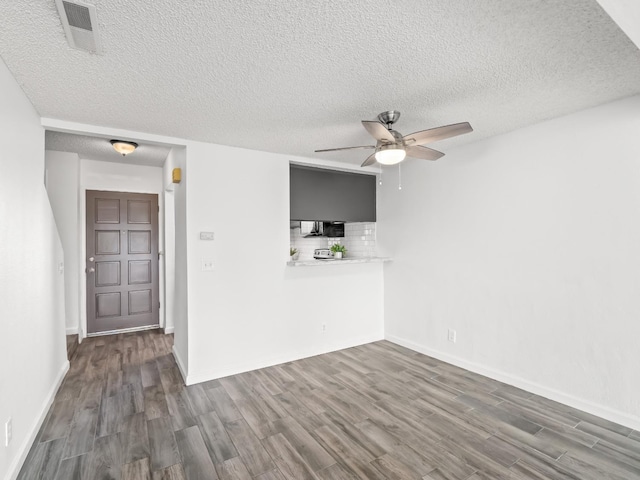 unfurnished living room featuring dark hardwood / wood-style flooring, a textured ceiling, and ceiling fan