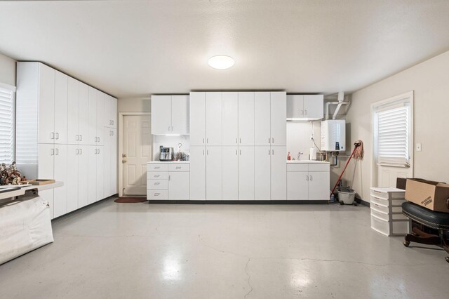 kitchen with white cabinetry and tankless water heater