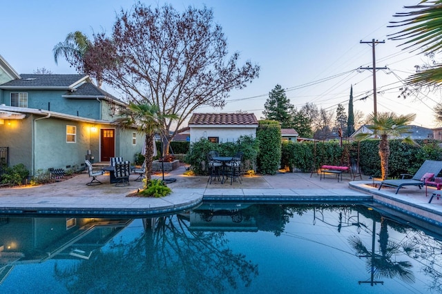 pool at dusk with a patio