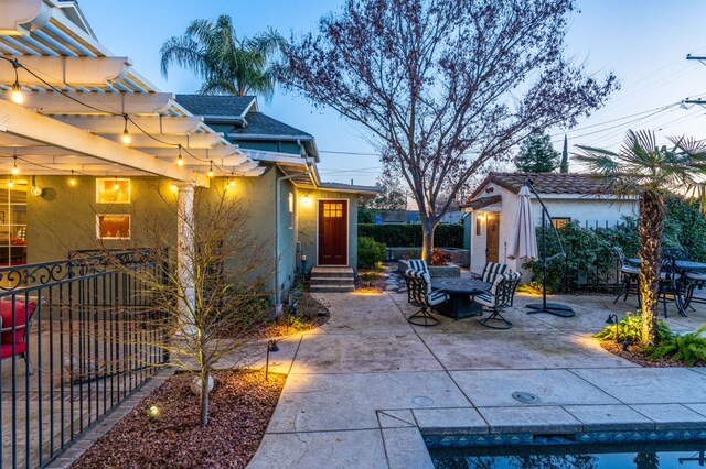 patio terrace at dusk featuring a pergola