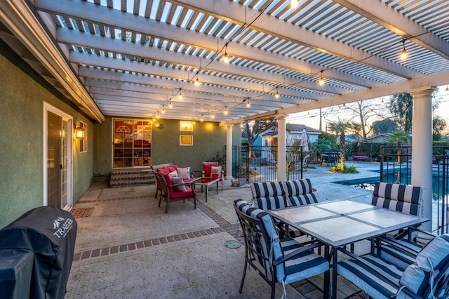 patio terrace at dusk featuring grilling area and a pergola