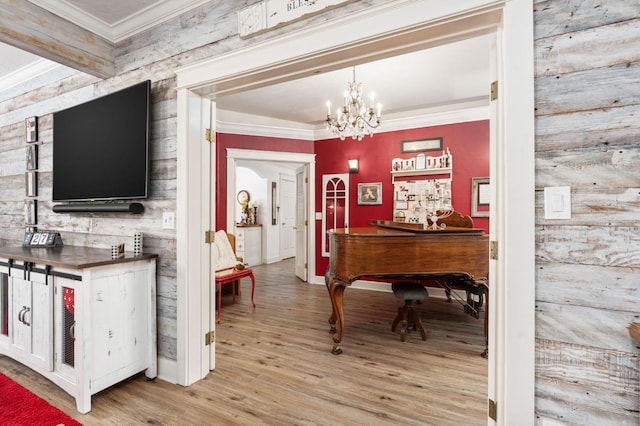 misc room with an inviting chandelier, beamed ceiling, and light wood-type flooring