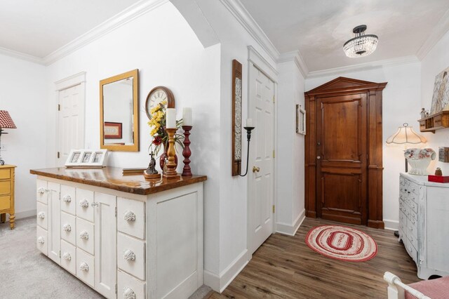 hall with ornamental molding and light wood-type flooring