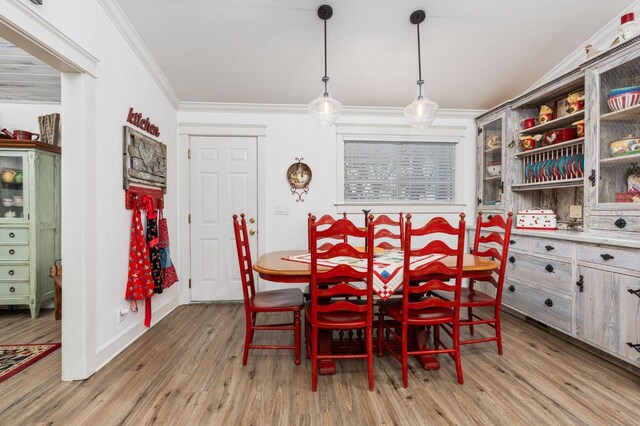 dining room featuring crown molding and light hardwood / wood-style floors