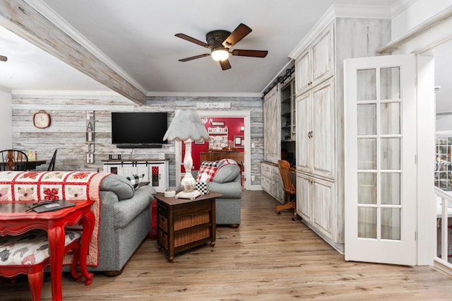 living room featuring light hardwood / wood-style flooring, ceiling fan, beam ceiling, wooden walls, and ornamental molding