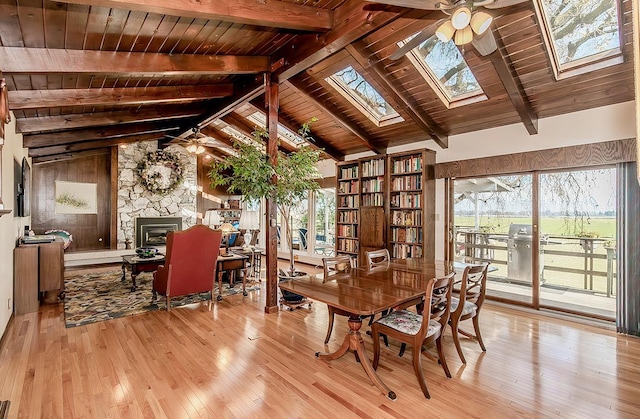 3670 S Newmark Ave, Sanger, CA 93654 - dining space featuring light wood-style floors, wood ceiling with exposed beams, healthy amount of natural light, a skylight, and a fireplace