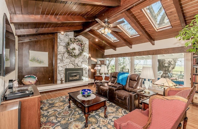 3670 S Newmark Ave, Sanger, CA 93654 - living room featuring wood ceiling, a skylight, wood finished floors, a ceiling fan, and a fireplace