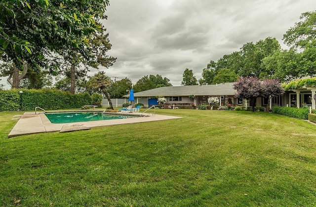 view of swimming pool featuring a lawn, a patio area, fence, and a fenced in pool