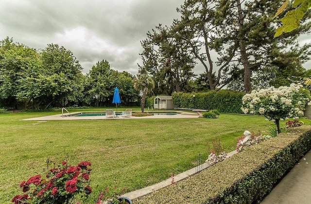 view of home's community featuring a swimming pool, an outdoor structure, a yard, and a shed
