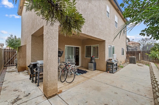 rear view of house with central AC unit and a patio area