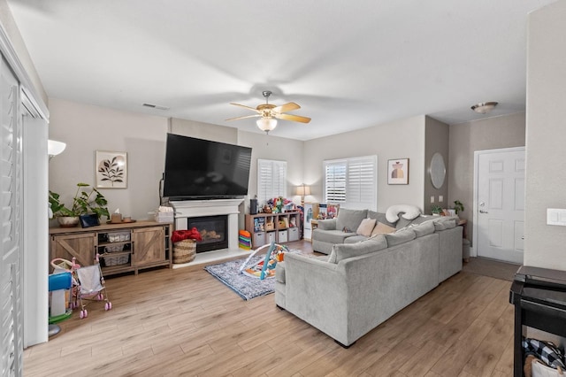 living room with light hardwood / wood-style floors and ceiling fan