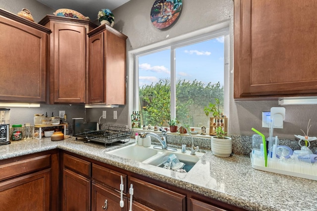 kitchen with light stone counters and sink