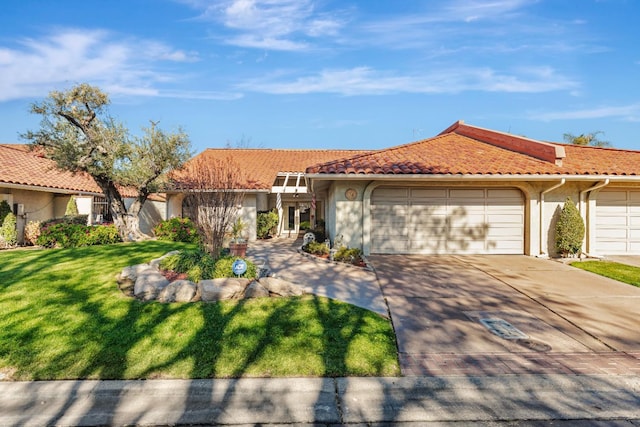 mediterranean / spanish house featuring a garage and a front lawn