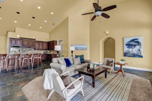 living room with ceiling fan and high vaulted ceiling