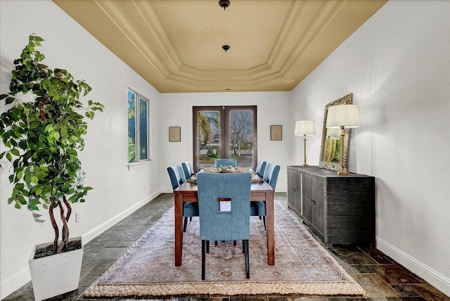 dining area with french doors, ornamental molding, and a tray ceiling