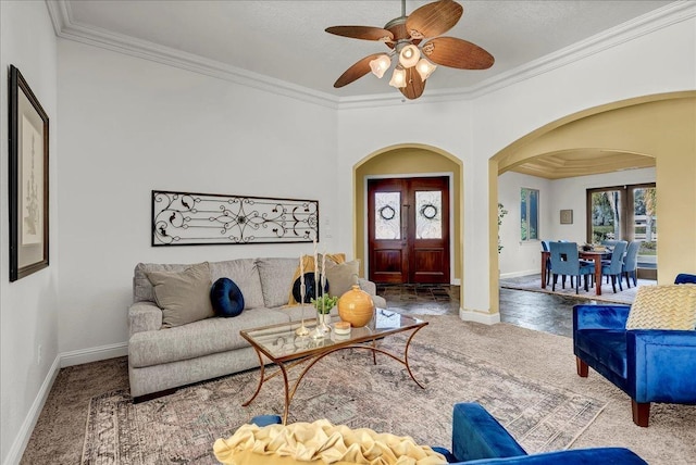 carpeted living room with ornamental molding and ceiling fan