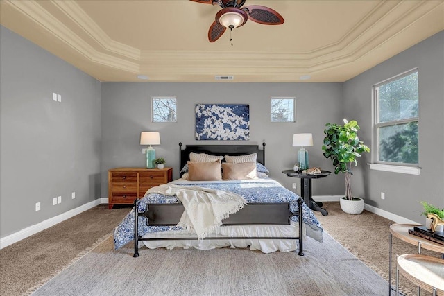 carpeted bedroom featuring ornamental molding, ceiling fan, and a tray ceiling