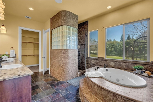 bathroom with vanity, shower with separate bathtub, and a wealth of natural light