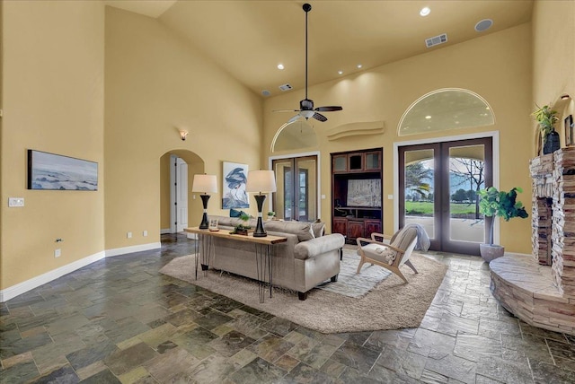 living room featuring french doors, a towering ceiling, and ceiling fan