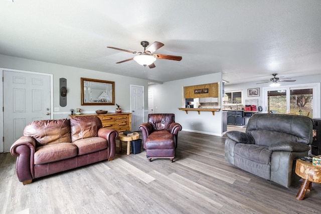 living room featuring hardwood / wood-style flooring, a textured ceiling, and ceiling fan