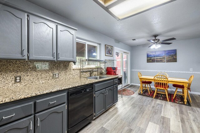 kitchen with tasteful backsplash, dishwasher, sink, and light hardwood / wood-style floors