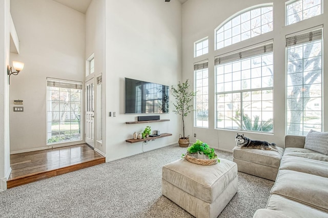 living room with carpet floors and a towering ceiling