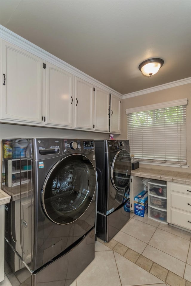 clothes washing area with cabinets, crown molding, separate washer and dryer, and light tile patterned flooring