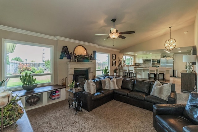 living room featuring vaulted ceiling, ceiling fan with notable chandelier, and crown molding