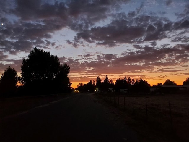 nature at dusk featuring a rural view