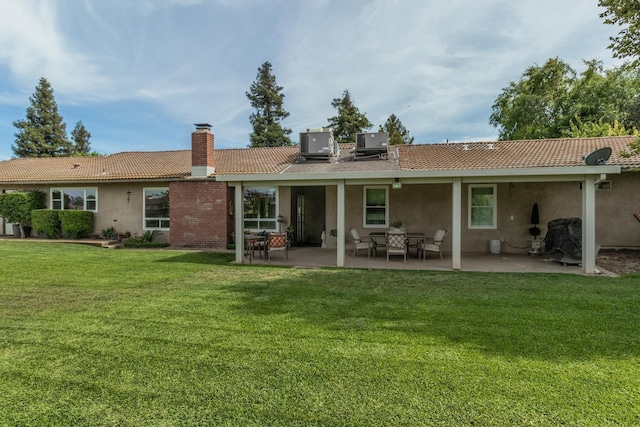 rear view of property with a yard, a patio area, and central air condition unit