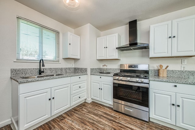 kitchen featuring white cabinetry, sink, stainless steel gas stove, and wall chimney exhaust hood