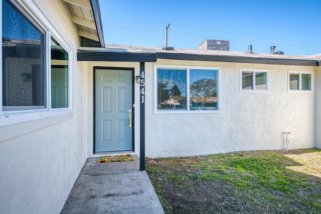 property entrance featuring a lawn