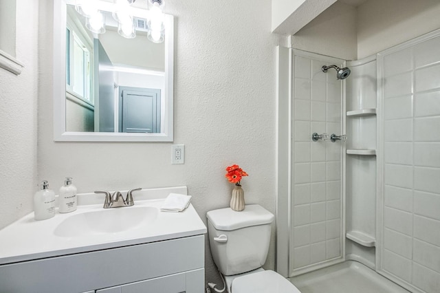 bathroom featuring vanity, walk in shower, and toilet