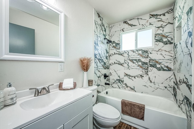 full bathroom with tiled shower / bath, vanity, and toilet