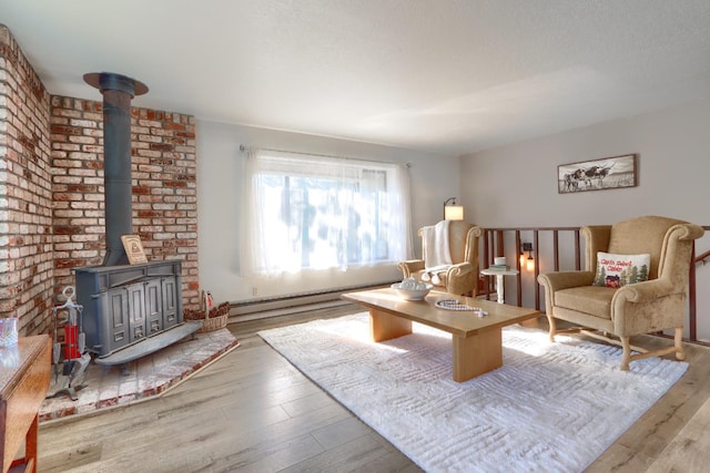 living room with hardwood / wood-style flooring, a baseboard radiator, a wood stove, and a textured ceiling