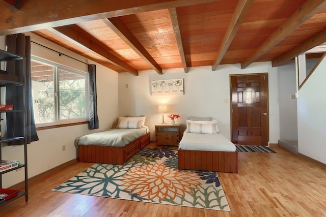 bedroom featuring beamed ceiling, wooden ceiling, and light hardwood / wood-style floors