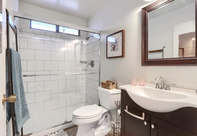 bathroom with vanity, a shower with shower door, and toilet